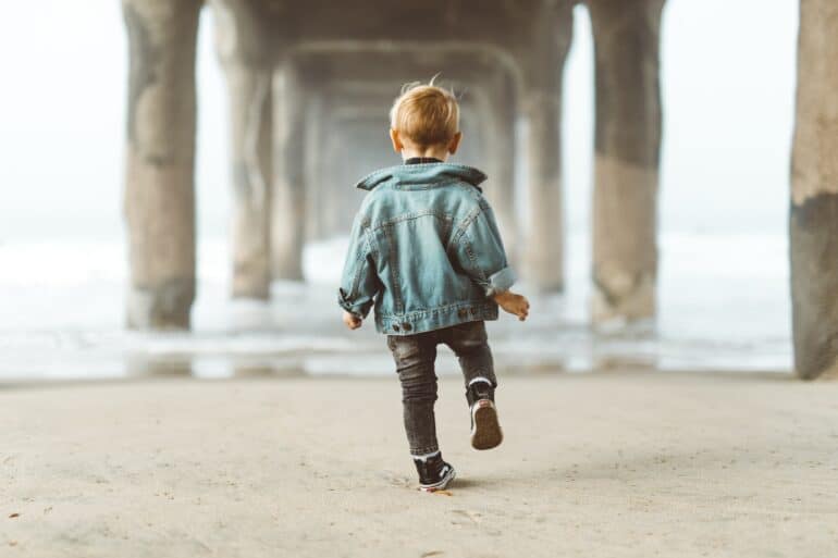 kid walking under a bridge