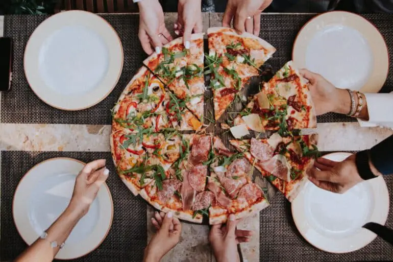 people grabbing a pizza