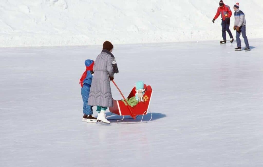 mother and child pulling baby sleigh on Rideau Canal