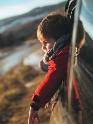 family road trip with toddler looking out van window