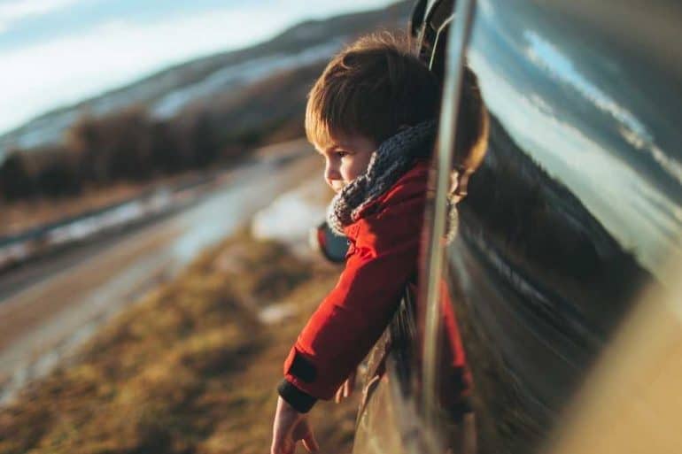 family road trip with toddler looking out van window