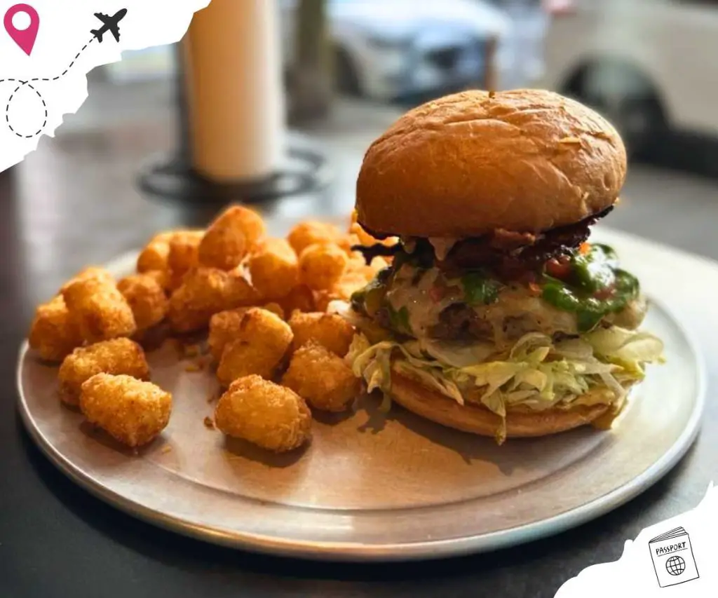 A Kryptonite Burger on a plate with a side of tots.