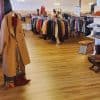 Vintage clothing shop interior with racks of colorful apparel, shoes, and accessories for travel and destination-inspired fashion, highlighting shopping destinations.