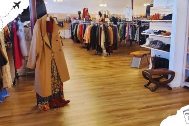 Vintage clothing shop interior with racks of colorful apparel, shoes, and accessories for travel and destination-inspired fashion, highlighting shopping destinations.
