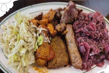 Succulent Ethiopian cuisine platter with injera, seasoned meats, and spicy cabbage, showcasing authentic flavors and traditional ingredients for a memorable dining experience.