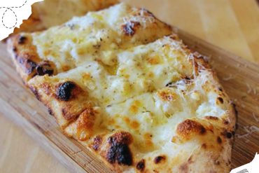 Cheese pizza on a wooden serving board with a golden crust and melted cheese, showcasing delicious Italian cuisine and perfect travel food options.