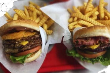 Juicy cheeseburgers with crispy fries served on a red tray, perfect for American fast food lovers and travel food experiences.
