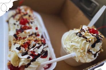 Delicious ice cream sundaes topped with whipped cream, chocolate syrup, nuts, and cherries in a takeout box, perfect for dessert travel snacks.