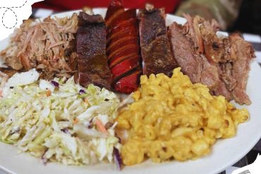 Smoked BBQ ribs with mac and cheese, coleslaw, and roasted red peppers served on a white plate, perfect for American barbecue and southern cuisine enthusiasts.