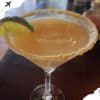 - Refreshing margarita cocktail with salted rim and lime wedge on a wooden table.