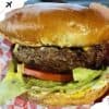 Juicy cheeseburger with fresh lettuce, tomato, and crispy bun, showcasing delicious American fast food. Perfect for food lovers exploring top travel destinations with renowned cuisine.