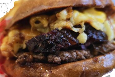Juicy cheeseburger with melted cheese, crispy bacon, and sizzling beef patty in toasted bun for a satisfying fast-food experience.
