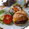 Beef burger with lettuce, tomato, pickles, and side salad on white plate, fast food meal, American cuisine, casual dining, delicious comfort food, popular restaurant dish, Go To Destinations travel concept, road trip food, culinary travel photos.