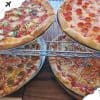 Delicious assorted pizzas on metal racks, featuring pepperoni, sausage, and veggie toppings, served at a restaurant for a delightful dining experience.