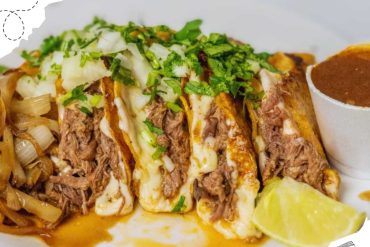 Succulent Mexican beef barbacoa taco topped with fresh cilantro and onions, served with lime and rich sauce, representing authentic local cuisine for travelers exploring destinations.