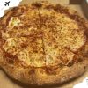 Fresh baked pepperoni pizza in a box showcasing delicious cheesy toppings and a crispy crust. Perfect for travel and dining experiences at top destinations.
