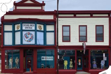 Colorful vintage storefront with mannequin displays, featuring a sign that reads "Casablanca Vintage," located on a city street, perfect for vintage shopping and exploring historic local shops.