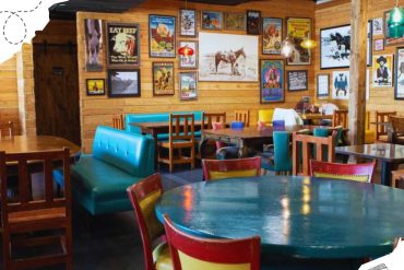 Vintage Western-themed restaurant interior with colorful chairs, wooden walls, and cowboy posters, creating a rustic and inviting atmosphere for travelers at Go To Destinations.