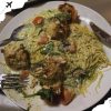 Creamy chicken and vegetable pasta dish with herbs, served with fried chicken pieces on a white plate, featuring a rich sauce and fresh ingredients, perfect for travel food experiences.