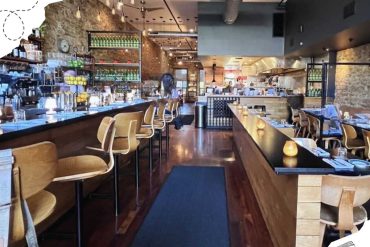 Modern cozy restaurant with warm lighting, rustic brick walls, and a stylish bar area, offering upscale dining experiences and a welcoming ambiance for food lovers and travelers.