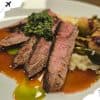 Juicy grilled steak with broccoli, mashed potatoes, and vegetable medley on white plate, featuring savory sauce for a delicious meal. Perfect for food lovers and gourmet dining experiences.