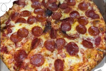 Delicious pepperoni pizza with melted cheese on a crispy crust, showcasing a classic American-style pizza perfect for travel food cravings.
