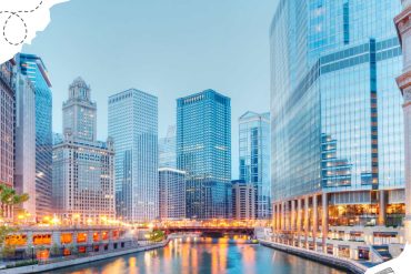 Skyscrapers in downtown Chicago reflecting on the Chicago River during sunset, showcasing modern architecture and vibrant city life. Perfect for travel and city destination travel photos.