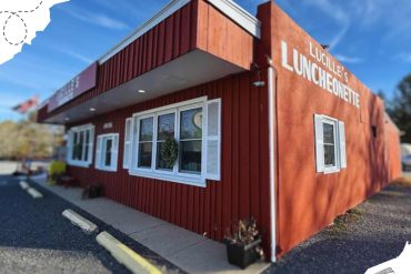 LUCILLE'S LUNCHEONETTE exterior view, red building with white window shutters, inviting breakfast and lunch restaurant, great travel destination spot in a charming neighborhood.