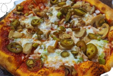 Savory mushroom and jalapeño pizza with melted cheese on a golden crust, perfect for travel food lovers and exploring new destinations.
