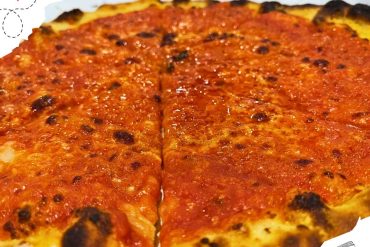 A pizza with just tomato sauce.