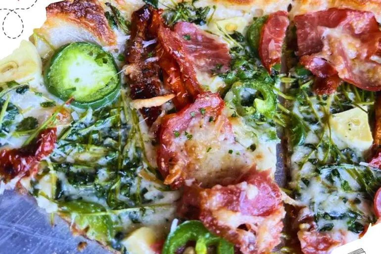 A close up of a slice of pizza with jalepenos and pepperoni.