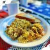 Savory breakfast scramble with eggs and herbs served with toast on a white plate, ideal for travel breakfast experiences, explore delicious local cuisine with Go To Destinations.