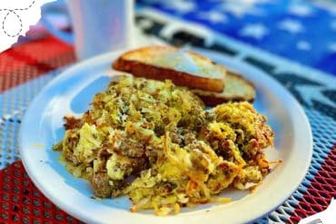 Savory breakfast scramble with eggs and herbs served with toast on a white plate, ideal for travel breakfast experiences, explore delicious local cuisine with Go To Destinations.