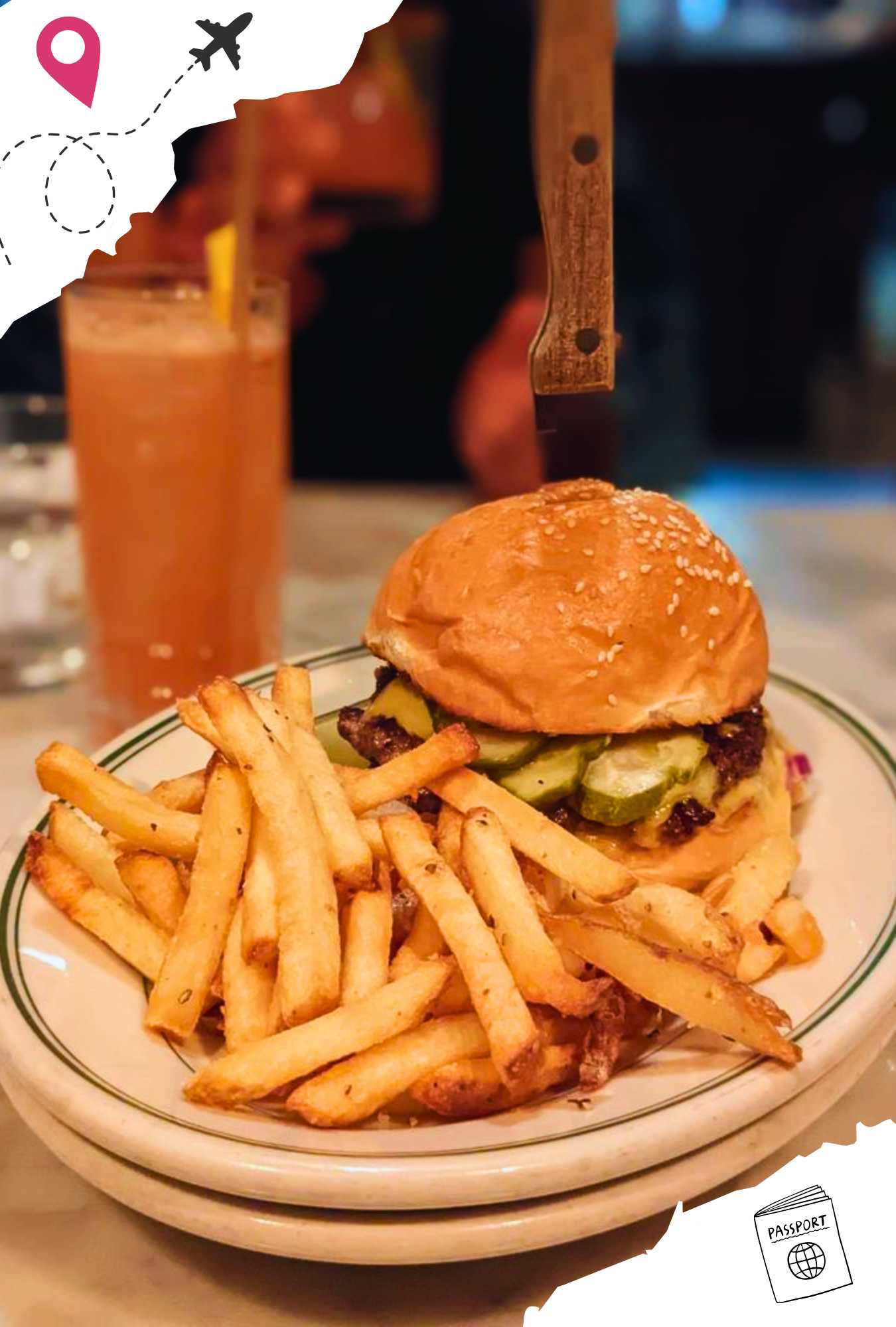 A burger with a knife stuck in the top and a side of French fries.
