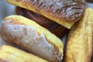 Crispy fried pastries filled with custard and chocolate, traditional European desserts, sweet treat for travel snacks or vacation indulgence.