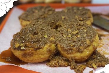 Savory Nigerian fried plantains topped with rich, spicy, and flavorful ground beef sauce, served on an orange tray. A delicious street food dish perfect for authentic Nigerian cuisine experiences.