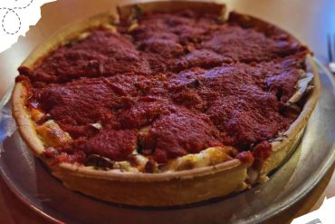 Spicy pepperoni pizza with melted cheese on a classic crust served on a silver platter, showcasing authentic flavors and delicious toppings. Perfect for sharing in an Italian or casual dining setting.