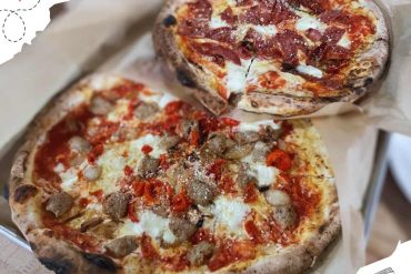 Freshly baked gourmet pizzas featuring unique toppings like sausage, vegetables, and bacon, perfect for food lovers exploring top destinations and culinary delights around the world.