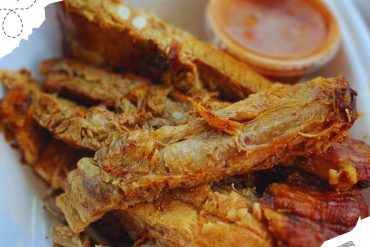 Crispy fried fish with dipping sauce and lemon, popular seafood dish, fresh local cuisine, restaurant meal, delicious fish fillets, seafood delicacy, authentic culinary experience, destination food tour.