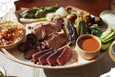 Juicy grilled meats, roasted vegetables, and flavorful sauces on a traditional platter, showcasing authentic international cuisine. Perfect for food lovers seeking diverse global travel experiences.