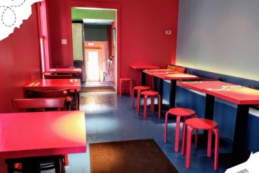 Bright red and blue themed restaurant interior with modern seating and tables, perfect for travel and leisure dining experiences.