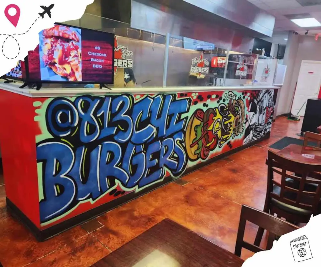 Colorful graffiti-style burger restaurant counter with vibrant artwork and signage.