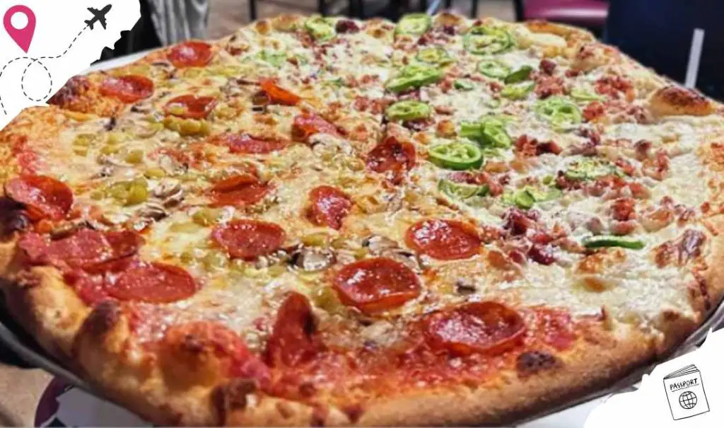 Gourmet pizza with pepperoni, green bell peppers, and mushrooms on a crispy crust at a pizzeria.
