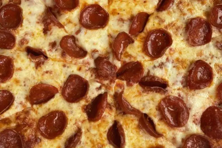 Cheesy pepperoni pizza with crispy crust, close-up view, ideal for pizza lovers and fast food enthusiasts.