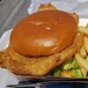 Buttermilk fried chicken sandwich with rich gravy and fries, fast food meal, comfort food, crispy chicken, delicious lunch, American cuisine, savory sandwich, casual dining, food photography.