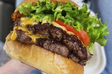 Juicy cheeseburger with fresh lettuce, tomato, and melted cheese on a toasted bun, perfect for a quick and delicious meal.