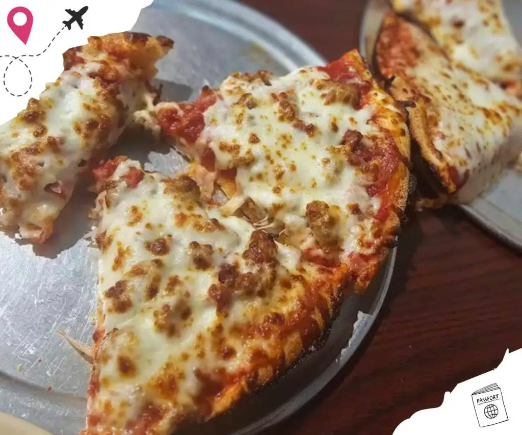 Hot cheesy pizza slices with melted mozzarella cheese, tomato sauce, and toppings on a silver tray, close-up photo for pizza lovers, delicious comfort food, ideal for travel and food destination content.