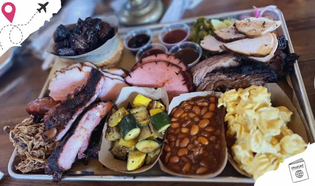 Juicy smoked meats, barbecue sides, and flavorful condiments on a metal tray, perfect for a Southern-style BBQ feast or a hearty meal to enjoy at a restaurant or outdoor gathering.