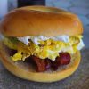 Crispy bacon and fluffy scrambled eggs breakfast sandwich on a toasted bun, perfect for a hearty morning meal. Ideal for breakfast lovers and egg sandwich enthusiasts.