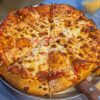 Cheese pizza with melted cheese and crispy crust, served hot on a metal tray, perfect for pizza lovers and casual dining experiences, showcasing popular American comfort food.